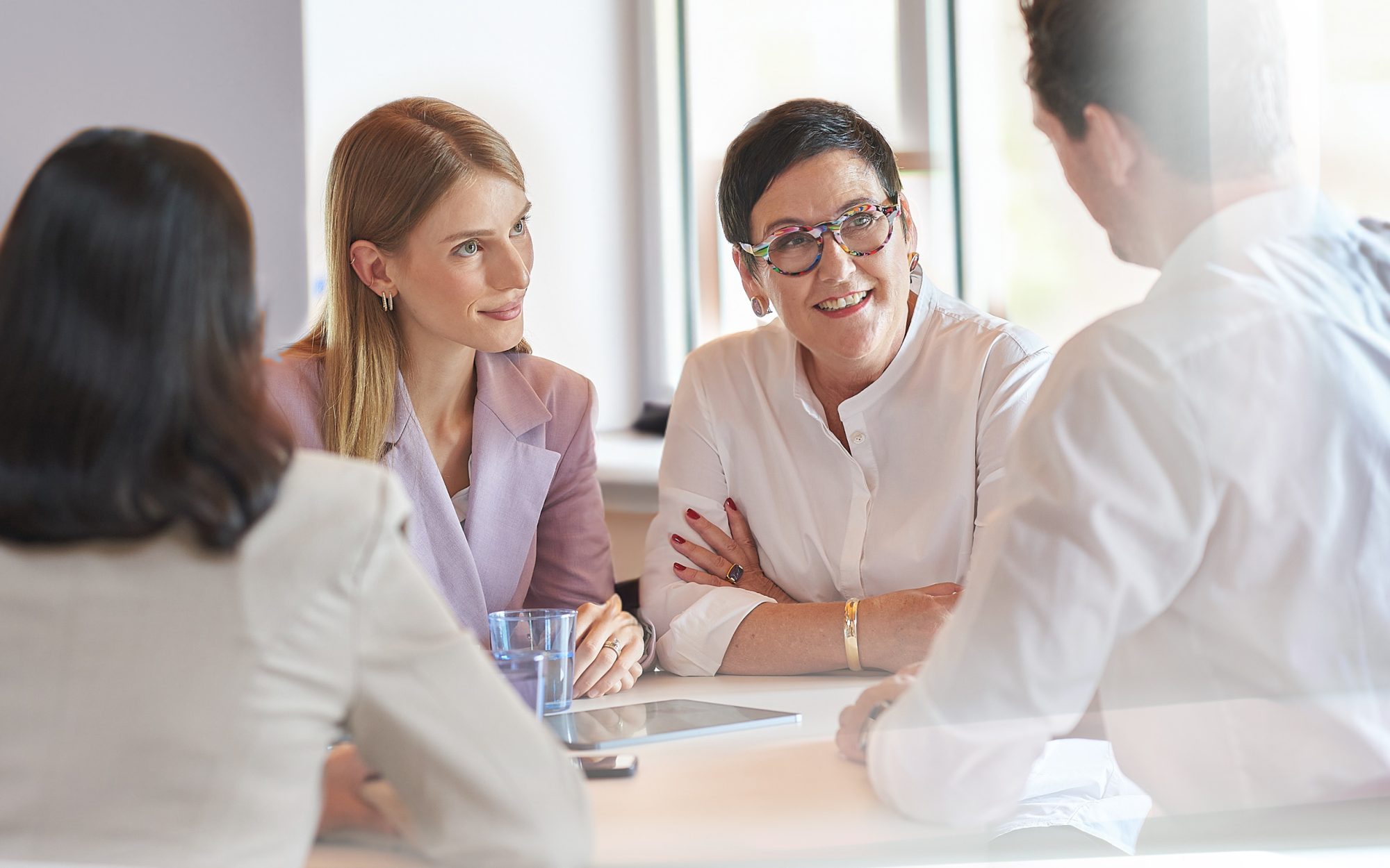 Team sitzt gemeinsam am Tisch und lacht